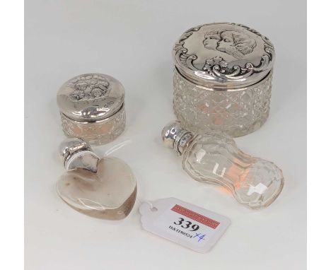 An early 20th century scent bottle, having a clear glass heart shaped body with silver cap and collar; together with another 