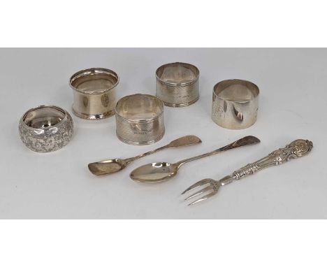 A pair of George V silver napkin rings, having engine turned decoration, together with three other napkin rings, two spoons a