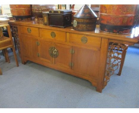 A Chinese oak scroll desk with three short drawers and cupboards below flanked by pierced floral brackets 32" x 85" x 19" 