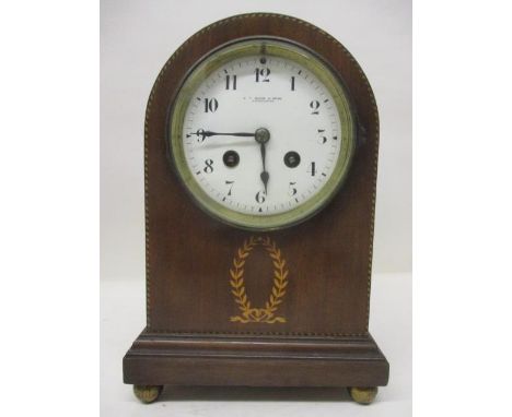An Edwardian mahogany cased, domed mantle clock. The white dial having Arabic numerals and inscribed E T Biggs &amp; Sons, Ma