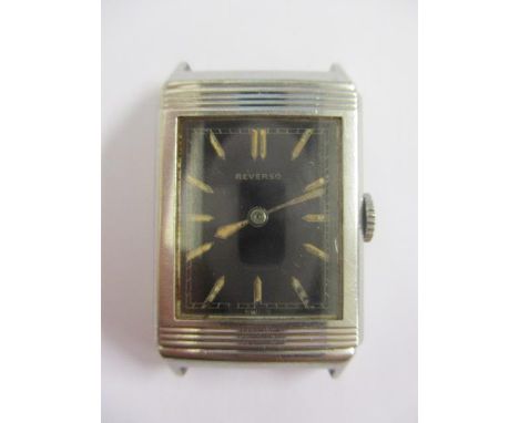 An early 1930s original Reverso gents, manual wind, stainless steel wristwatch. The black dial having batch luminous markers 