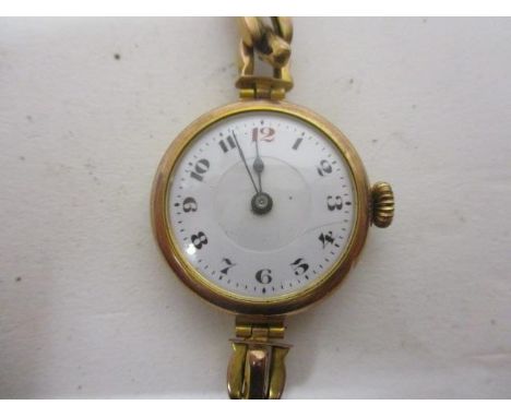 An early 20th century ladies manual wind 9ct gold wristwatch.  The white enamel dial having Arabic numerals and case back and