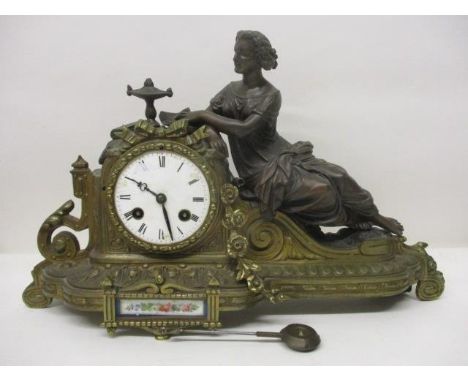 A 19th century French gilt metal mantle clock. The floral, scroll and ribbon case having a white enamel dial with porcelain p