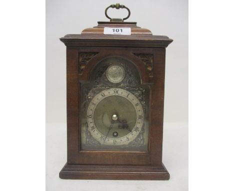An early 20th century mahogany cased mantle clock in a Charles Gretton style, the brass dial having cherub spandrels and a si