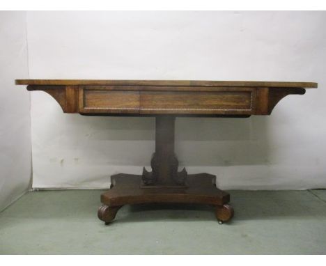 A Regency rosewood sofa table with split frieze drawer, over a square carved column and platform base, on carved feet and cas