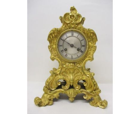 A mid 19th century French Raingo Freres, gilt metal mantle clock. The ornate, floral and scroll decorated case having a silve