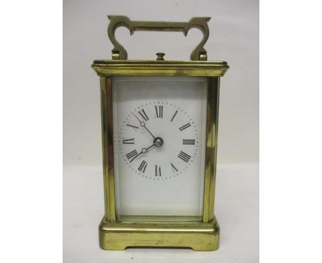 A late 19th/early 20th century brass repeating carriage clock, having a white enamel dial with Roman numerals, the 8 day move