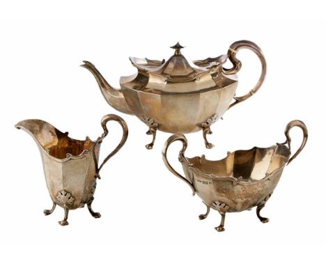 A silver 3-piece teaset by Kerr & Phillips, hallmarked Glasgow, 1909 of oval faceted form on 4-scroll feet, helmet shaped mil