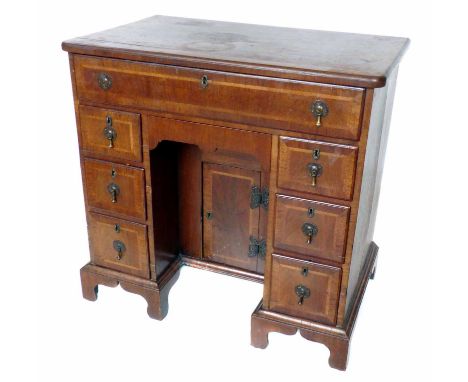 George III walnut veneered small kneehole desk, top with cross banding above one long and two stacks of three short drawers, 
