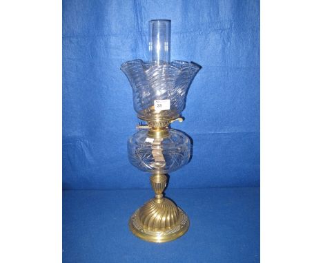 Brass double burner oil lamp with clear cut glass reservoir on a fluted and writhen brass pedestal base, cranberry glass wryt