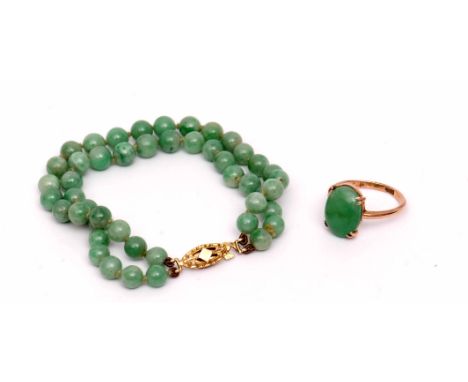 Mixed Lot: antique jade ring, oval cabochon shaped, the mount stamped 15ct, together with a jade bead bracelet featuring two 