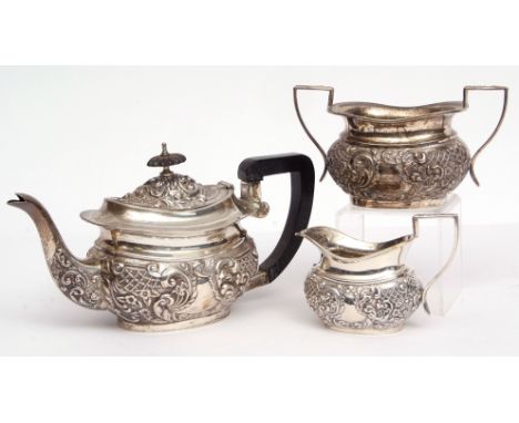 Edward VII three-piece bachelor's tea set comprising tea pot, sugar basin and milk jug, each of oval form with profusely embo