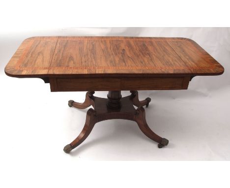 Regency period rosewood sofa table, the cross-banded top applied at either end with drop flaps over a frieze with two drawers