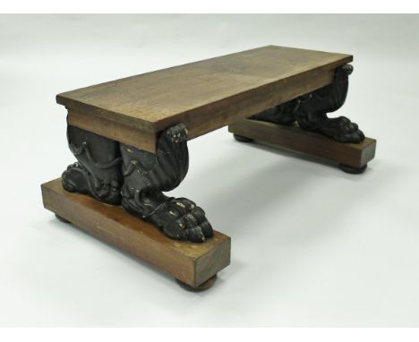 An early 19th Century mahogany ebonised low bench after a design by George Smith, the plank top on acanthus carved heavy lion