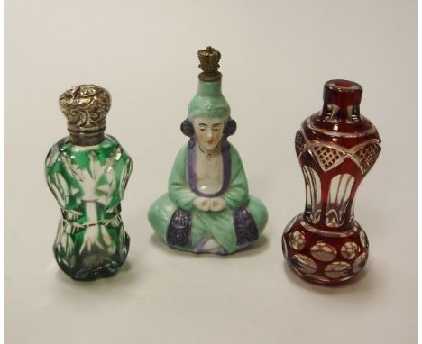 Two Victorian overlaid cut glass scent bottles one in green one in ruby, together with a Sitzendorf figural scent bottle as a