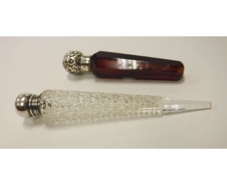 A cut glass conical scent bottle, a similar green glass example, an amber glass hobnail cut scent bottle, all with silver rim