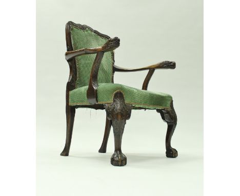 An 18th Century Irish walnut framed elbow chair, the shaped upholstered back with scrolling acanthus carved decorated top rai