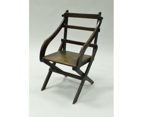A circa 1900 child's oak ladder back elbow chair on X frame base, 69 cm high