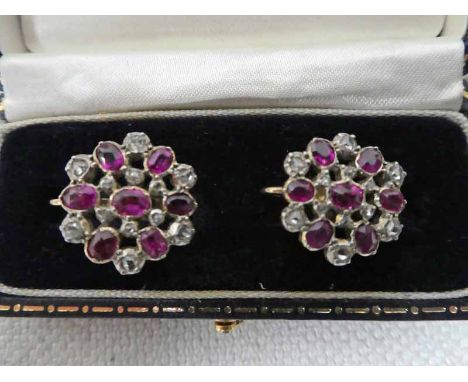 A pair of early 20th century, gold, diamond and ruby set screw back earrings, target style with twelve small diamonds intersp