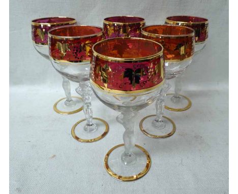 A set of six French Bayel Wine Glasses, ruby coloured and gilt grapevine highlighted bowl, supported figural stem featuring n