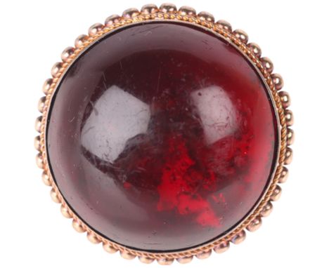 An Antique 9ct gold garnet dress ring, set with foil-back round cabochon garnet within beaded edge closed-back setting, unmar