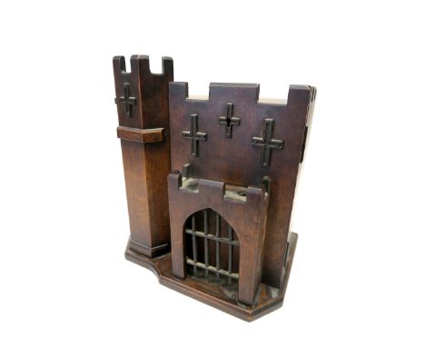 A Late XIX Century Oak Smoker's Cabinet, in the form of a castle, with pipe stand to the door, opening to reveal three drawer