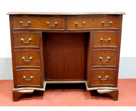 A XX Century Mahogany Serpentine Shaped Kneehole Desk, the crossbanded top with moulded edge over two drawers, flanking drawe