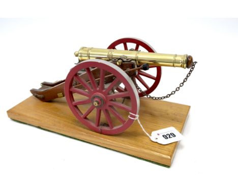 A Detailed Model of a Napoleonic Era Cannon on Wheels, attached to wooden plinth, 29cm long.