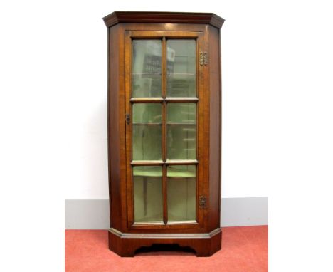 A XX Century Walnut Floor Standing Corner Cupboard, with stepped pediment, glazed door with three internal shelves, on bracke