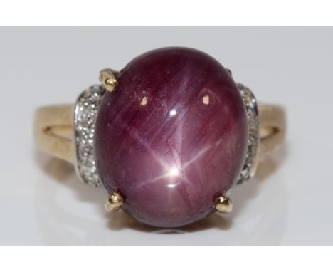 A 9ct gold star ruby cocktail ring with diamond set shoulders, N, claw in need of repair, 6.7g Conditon-Full UK hallmarks, al