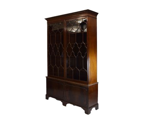 Early 20th Century mahogany library bookcase, with acanthus-carved dentil cornice over a pair of long glazed cabinet doors wi