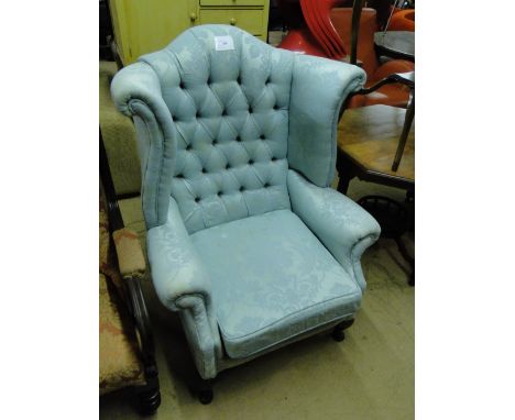 An Edwardian button back upholstered wing back armchair
