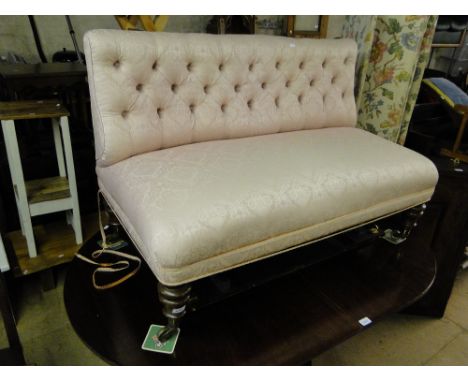 An Edwardian button back upholstered salon settee on turned legs