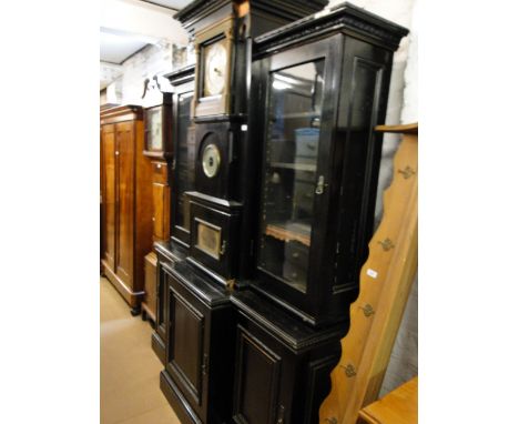 An unusual ebonised breakfront 2-section bookcase, the centre being fitted with a 30-hour clock and barometer flanked by open