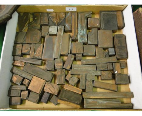 A box of copper faced print blocks depicting tools and ironmongery.