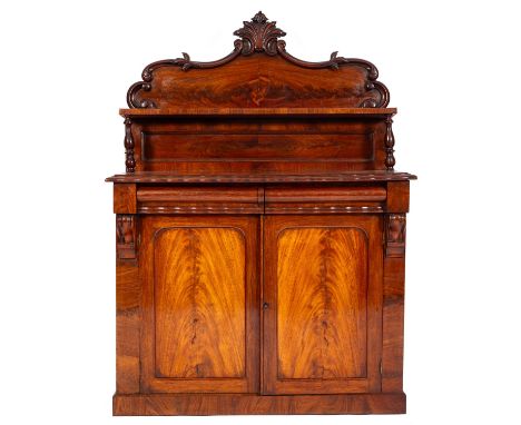 A Victorian mahogany chiffonier, the shaped and panelled shelved superstructure with carved acanthus scroll cresting on turne