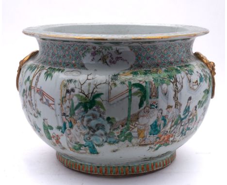 A Chinese famille verte jardiniere of bombé form with flattened rim and gilt lion-dog ring handles, painted with a continuous