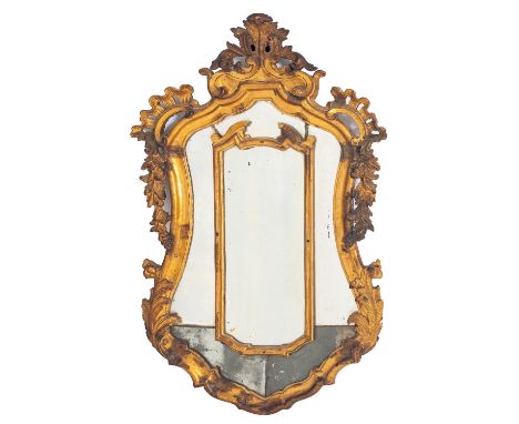 An Italian carved and giltwood framed marginal wall mirror, late 18th century; of cartouche form, with openwork scrolling fol