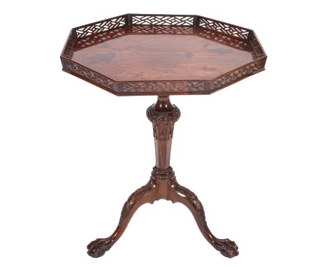 A carved mahogany occasional table in George III style, 19th century; the octagonal flip top with open latticeworked edging; 