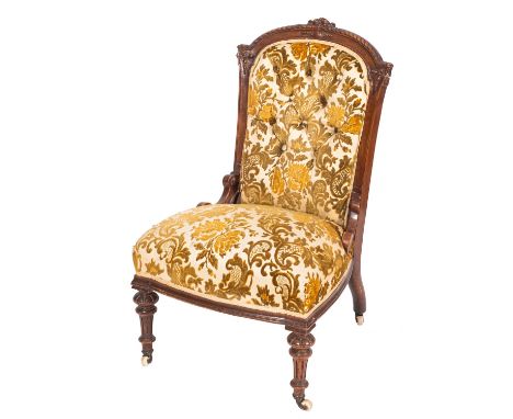 A late Victorian carved walnut and button upholstered salon chair, circa 1900; the arched backrest with gadrooned toprail; ab