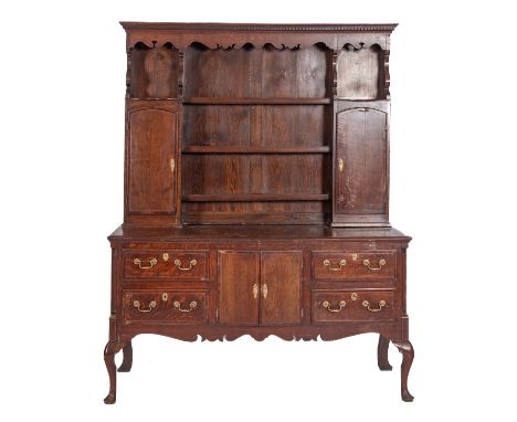 A George III oak and crossbanded dresser, circa 1800; the plate rack with dentilled cornice above fret-cut canopies; the shel