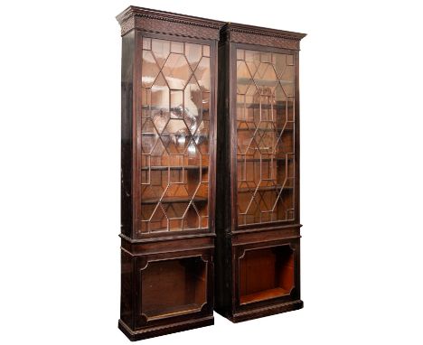 A pair of George III mahogany and glazed bookcases, late 18th century; each with moulded and dentilled cornice above a blind 