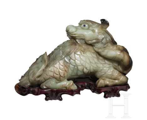Liegender Jade-Qilin, China, 20. Jhdt.  Grünbraune Jade. Figur eines in sich verschlungenen Qilins in der für die Ming-Dynast