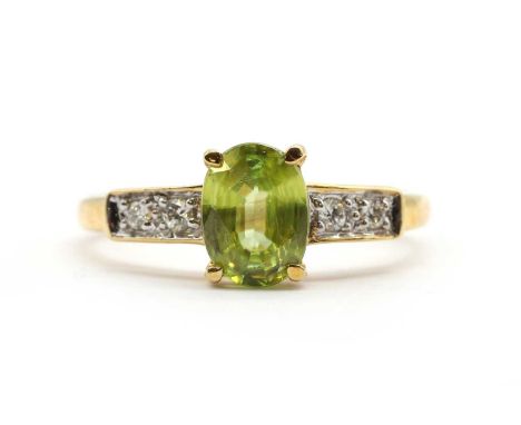 An 18ct gold sphene and diamond ring, with an oval mixed cut sphene, approximately 7.5 x 5.5mm, claw set, to shoulders grain 