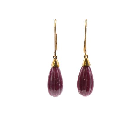 A pair of gold ruby drop earrings, with a carved fluted ruby pippin, approximately 16mm long, to plain cap and hook fittings,
