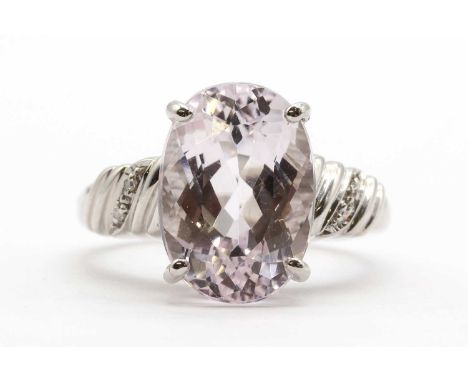 A 9ct white gold kunzite and diamond ring, with an oval mixed cut kunzite, approximately 14 x 10mm, claw set, to reeded shoul