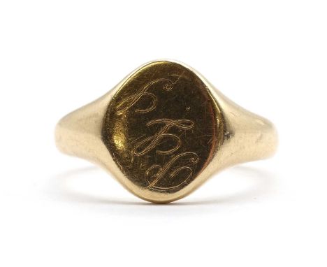 A 9ct gold signet ring, an oval head with engraved initials, to tapered shoulders and a plain shank, Birmingham 1966, 3.87g.F