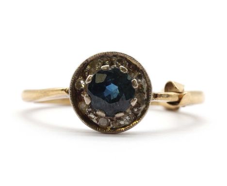 A gold sapphire and diamond cluster ring,with a round mixed cut sapphire to surround of eight cut diamonds, claw and grain se