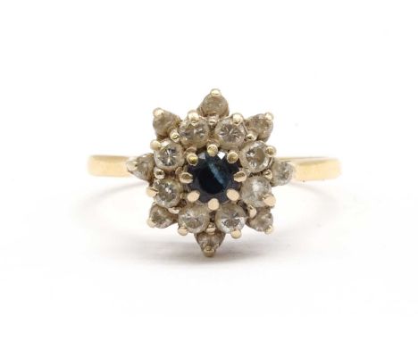 An 18ct gold sapphire and diamond cluster ring, with a central round mixed cut sapphire, to two row surround of brilliant cut