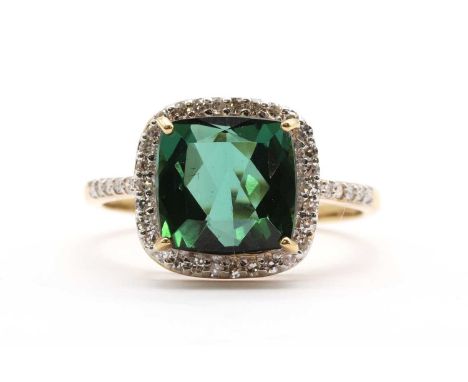 An 18ct gold green tourmaline and diamond halo cluster ring, with a cushion cut tourmaline, approximately 9mm, claw set to su